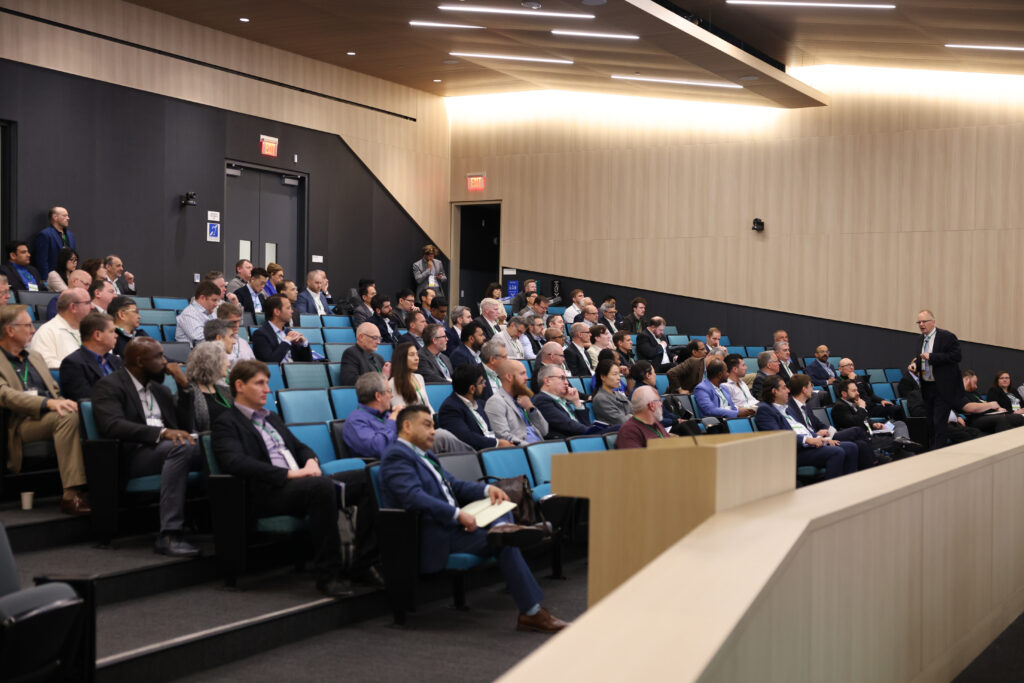 Professor Thomas Koch delivers the keynote presentation during the Inaugural Hydrogen Engine Alliance â€“ North America Conference, speaking to a full audience in a modern lecture hall.
